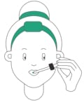 Iemand met een groene hoofdband gebruikt een druppelaar om Hemptouch - Gezicht Zonnebrandcrème SPF30 - minerale bescherming (50ml) op de tong aan te brengen.